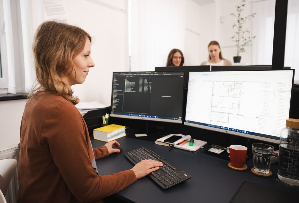 Architektenteam von BM Romar | Partner bei der digitalen Projektplanung am Computer mit Bauplänen.